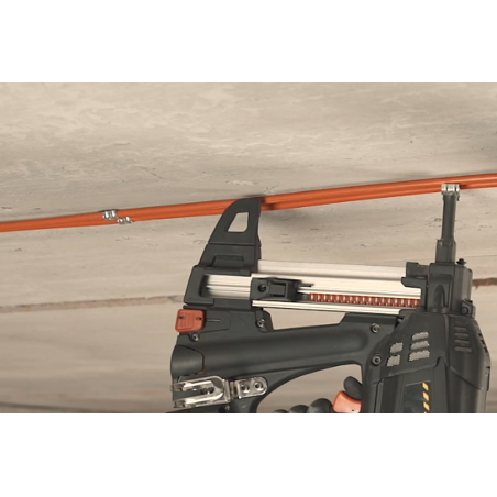 Alkalmazási kép a DFT lőhető tűzálló félköríves fém dupla bilincsről: a DFT a FORCE ONE gázos szegbelövő orr-részére helyezve két kábelt rögzít betonfödémhez.